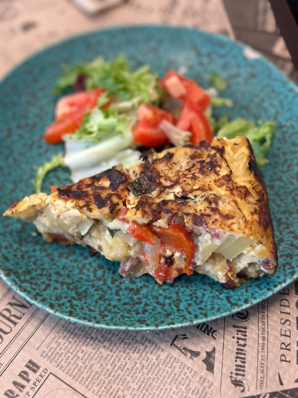 A wedge of tortilla with a side salad